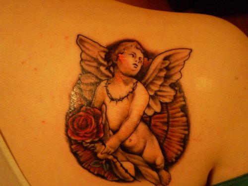 Grey Ink Flying Baby Angel With Red Rose Tattoo